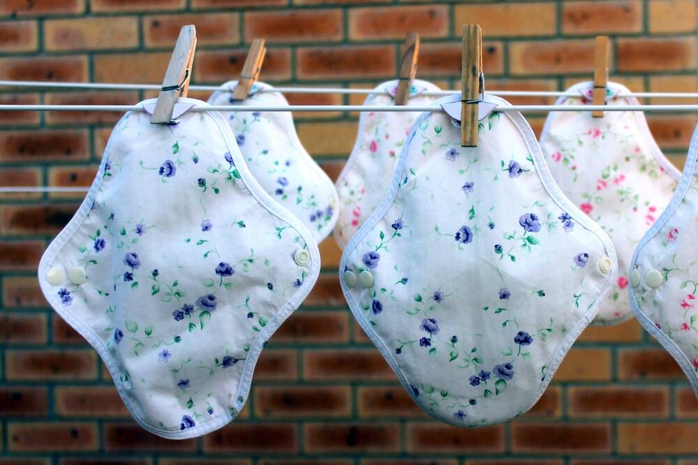 reusable,cloth,pads,with,flowers,on,a,washing,line.,female