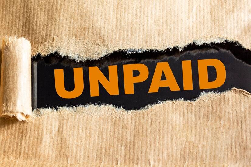 unpaid.,text,on,torn,brown,paper,and,black,background.
