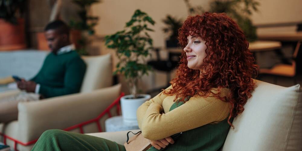 redhead,businesswoman,resting,in,comfortable,armchair,with,notebook,after,productive