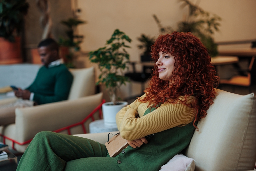 redhead,businesswoman,resting,in,comfortable,armchair,with,notebook,after,productive