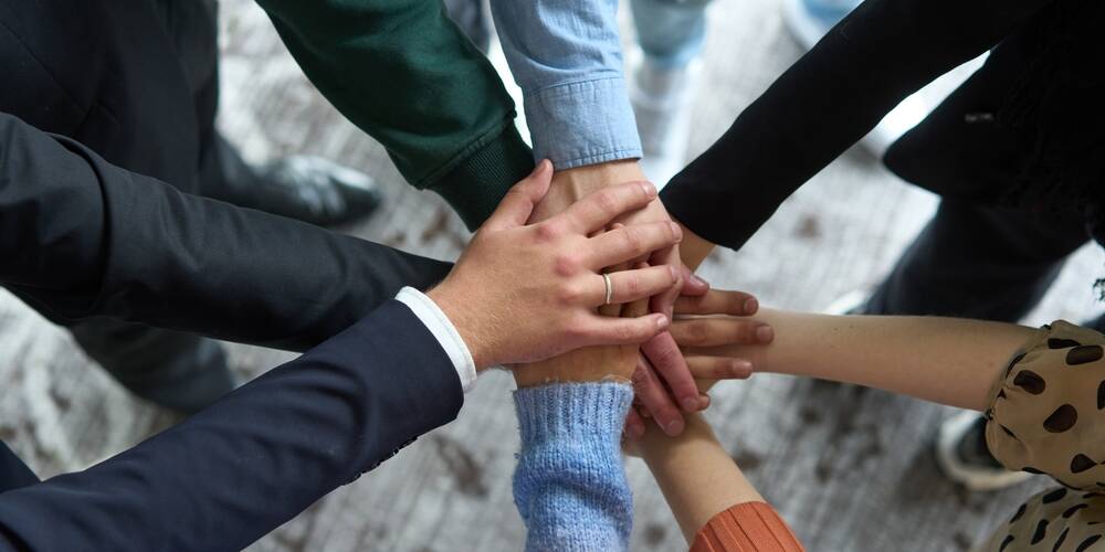 a,top,view,of,business,people,joining,hands,in,a