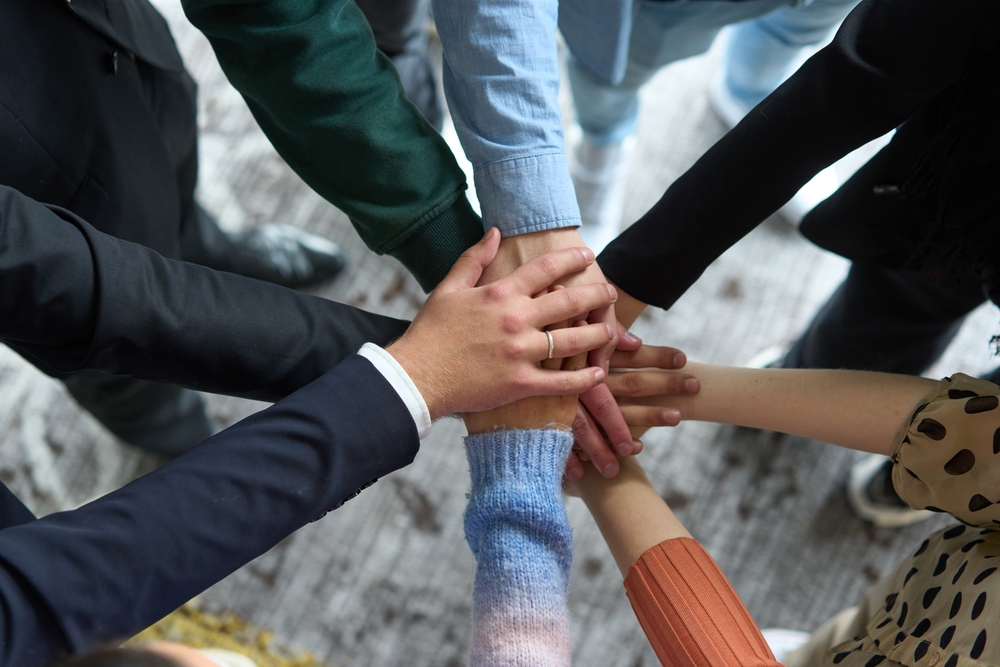 a,top,view,of,business,people,joining,hands,in,a