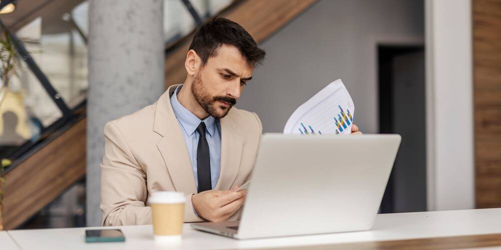 portrait,of,focused,corporate,worker,sitting,at,office,with,documents