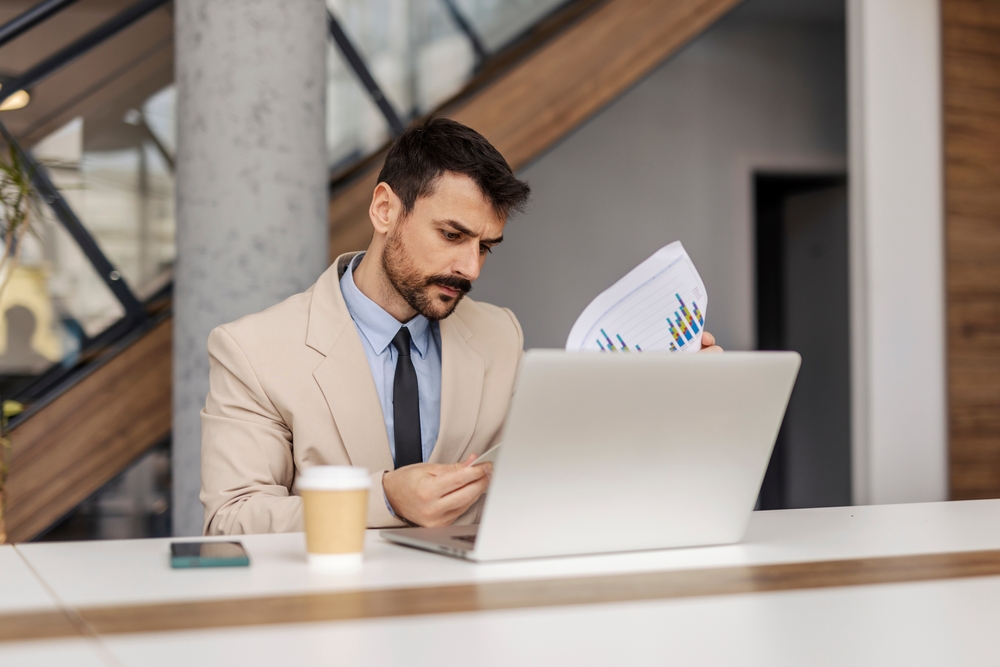 portrait,of,focused,corporate,worker,sitting,at,office,with,documents